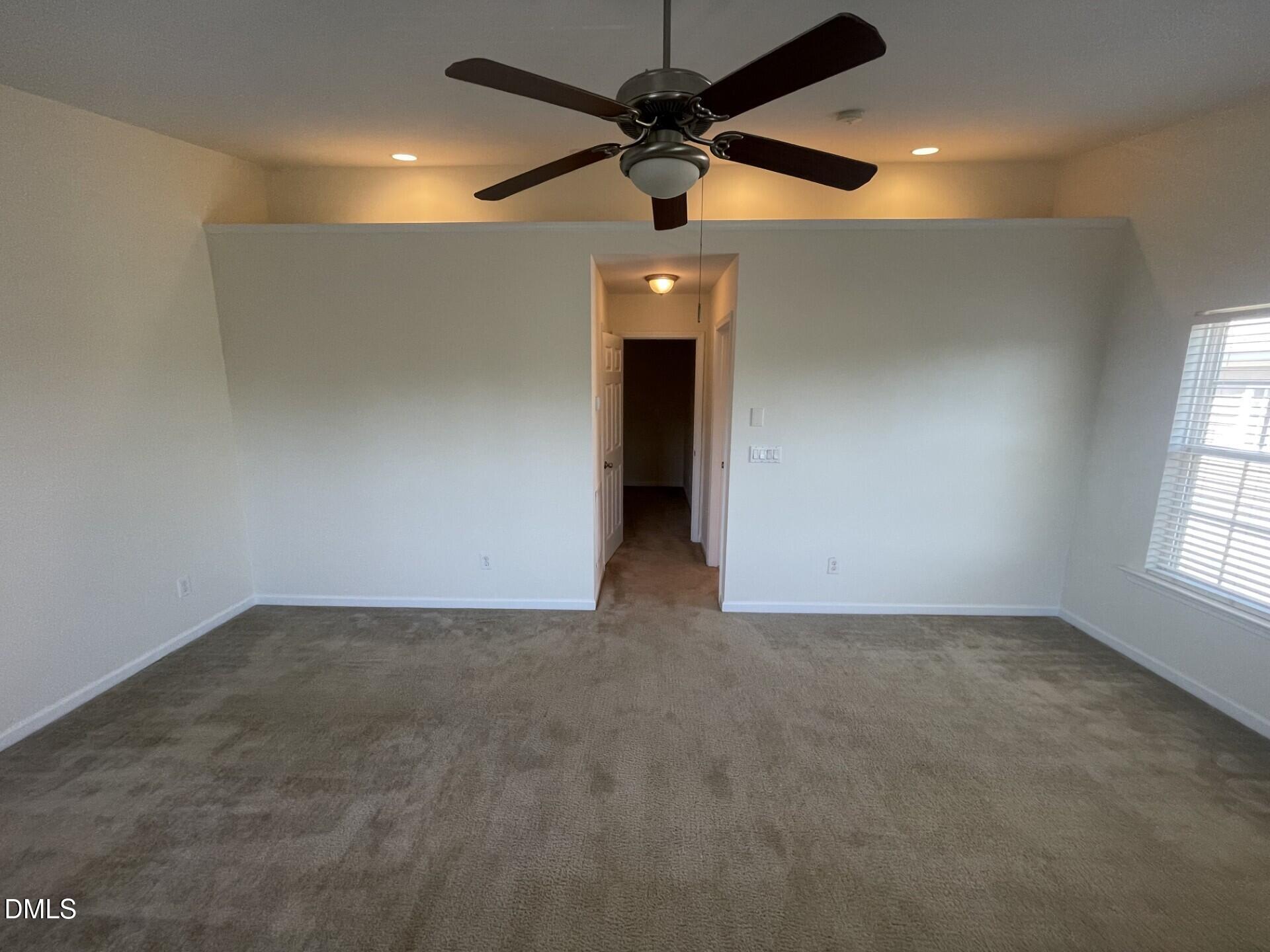 1130 Renewal Place, Unit 100 Raleigh, NC 27603 - Photo 7 of 17 an empty room with a ceiling fan and window