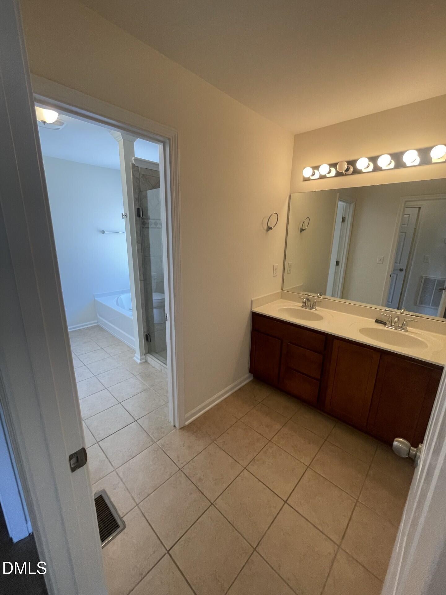 1130 Renewal Place, Unit 100 Raleigh, NC 27603 - Photo 9 of 17 a bathroom with a double vanity sink and a mirror