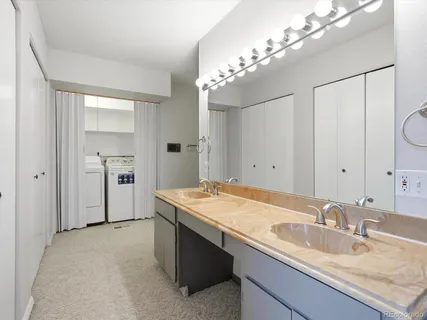 a bathroom with a granite countertop sink a large mirror and a shower
