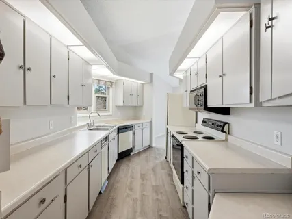 a kitchen with stainless steel appliances a sink stove and cabinets