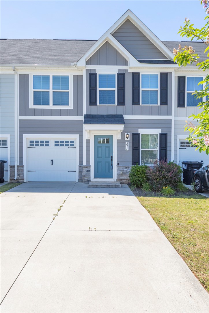 233 Scenic Road Anderson, SC 29621 - Photo 1 of 50 A welcoming townhome with a light blue entry door, attached garage, and neatly kept front landscaping.