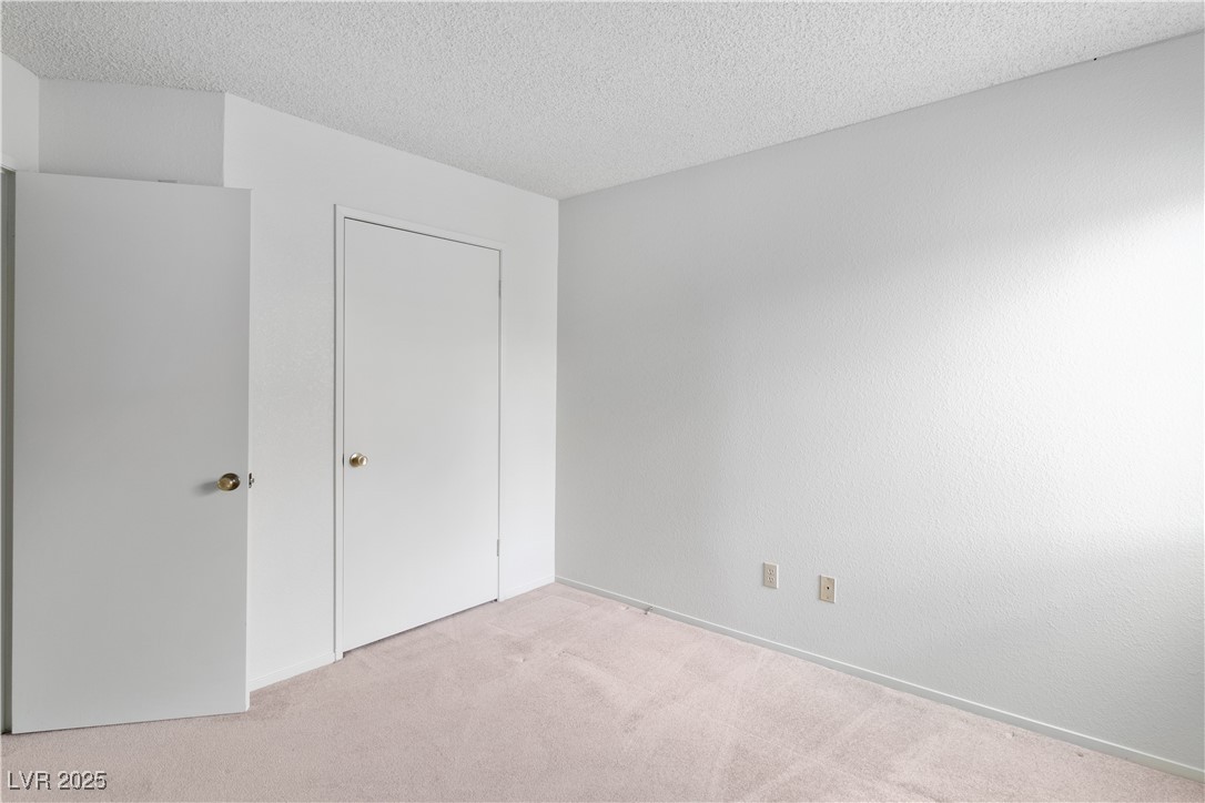 3740 Desert Marina Drive, Unit 2 Laughlin, NV 89029 - Photo 22 of 75 Second Bedroom with carpet, a textured ceiling, and a closet