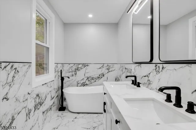 a bathroom with a bathtub sink and mirror