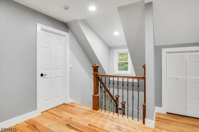 a view of a hallway with wooden floor and staircase