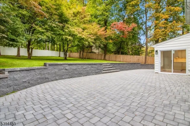 a view of a house with a yard and a large tree