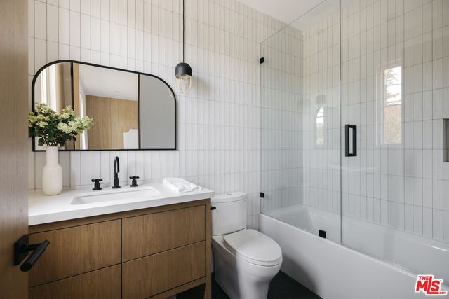 a bathroom with a granite countertop sink a mirror and shower