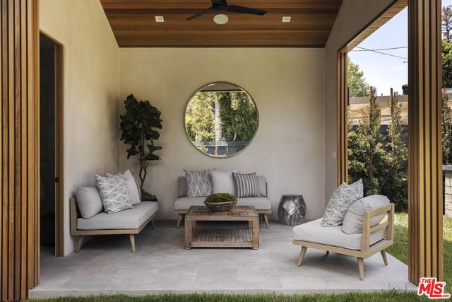 a view of a chair and table in backyard of the house