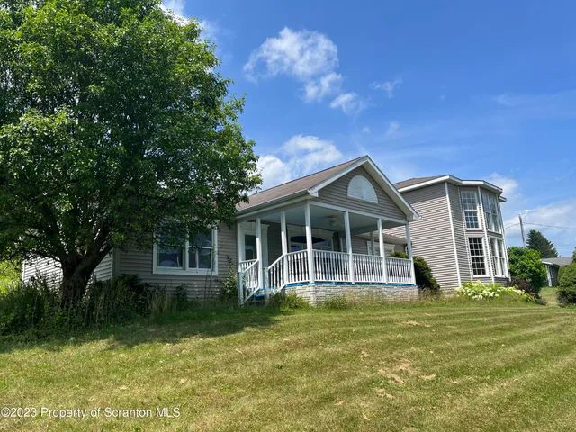 a view of a house with wooden fence and a yard