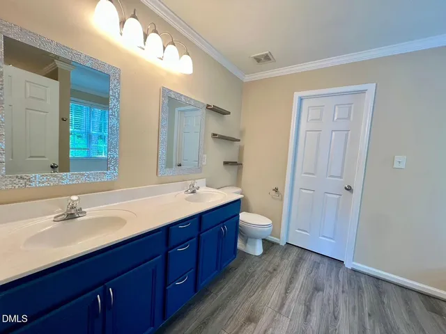 a bathroom with a double vanity sink and mirror with shower