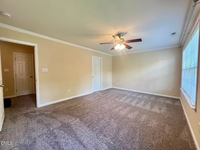 an empty room with a ceiling fan and a window