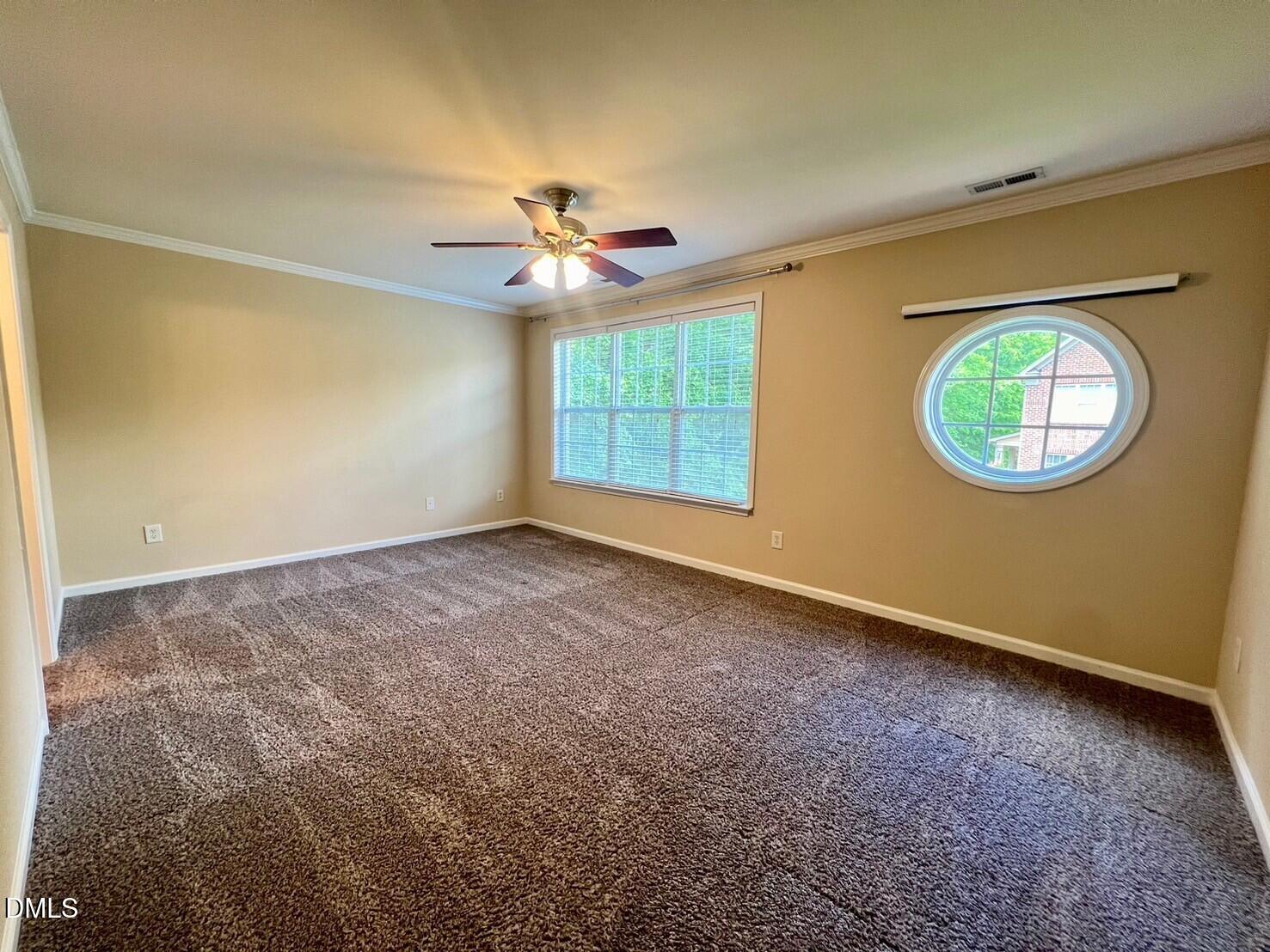 9912 Layla Avenue Raleigh, NC 27617 - Photo 15 of 25 an empty room with a window and a chandelier fan