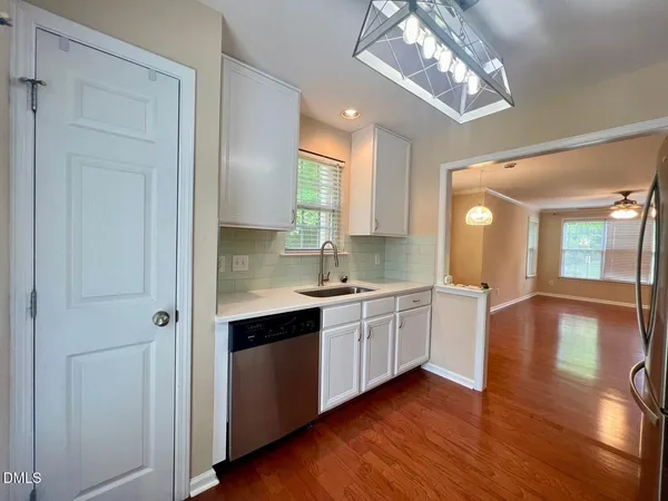 a large kitchen with a lot of counter space and a wooden floor