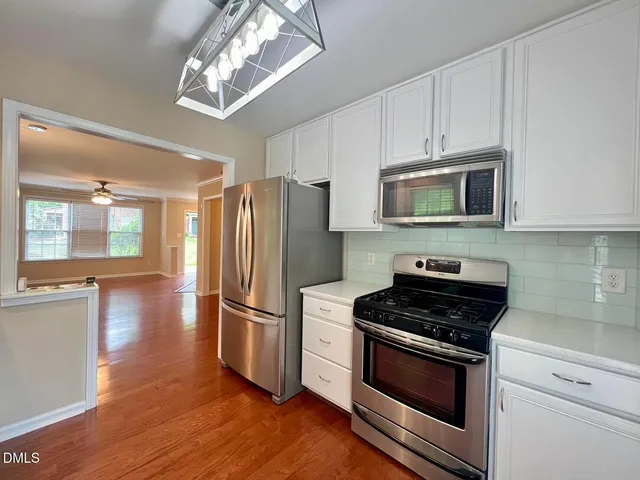 a kitchen with stainless steel appliances granite countertop a stove microwave and refrigerator
