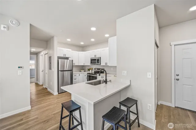 a kitchen with stainless steel appliances a refrigerator and a stove top oven