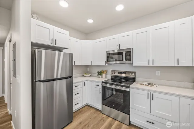 a kitchen with white cabinets and stainless steel appliances