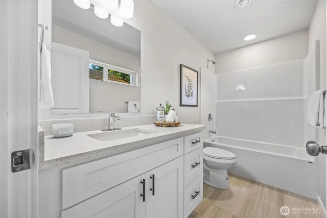 a bathroom with a toilet a sink a tub and mirror