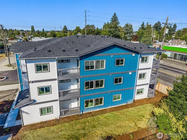 a view of a big house with a big yard and large trees