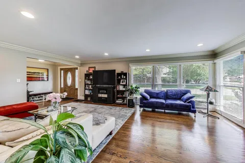 a living room with furniture a wooden floor and a large window