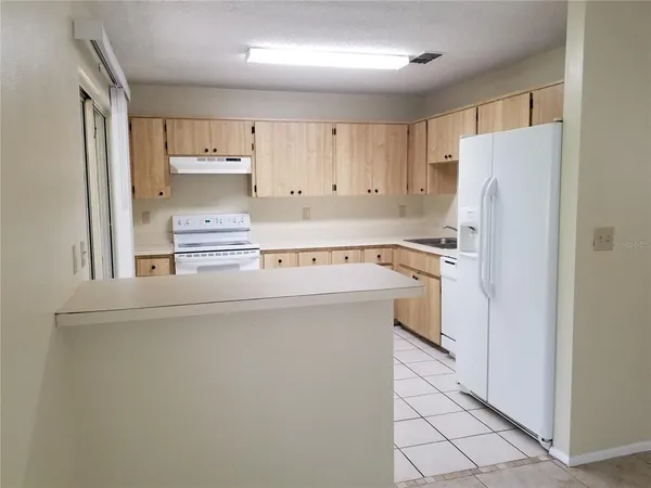 a kitchen with stainless steel appliances a refrigerator and white cabinets