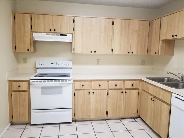 a kitchen with granite countertop white cabinets and white appliances