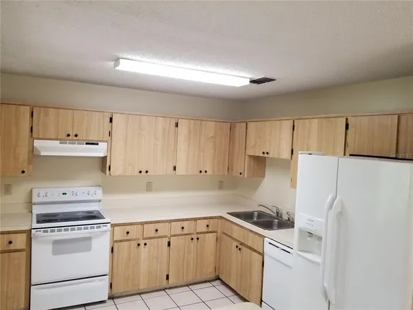 a kitchen with cabinets a refrigerator and a sink