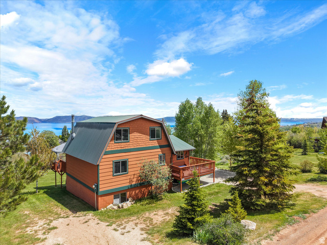 371 Lewis Loop, Unit 29 Fish Haven, ID 83287 - Photo 8 of 40 Gambrel-style residence featuring a dark green metal roof, orange siding, and a prominent deck