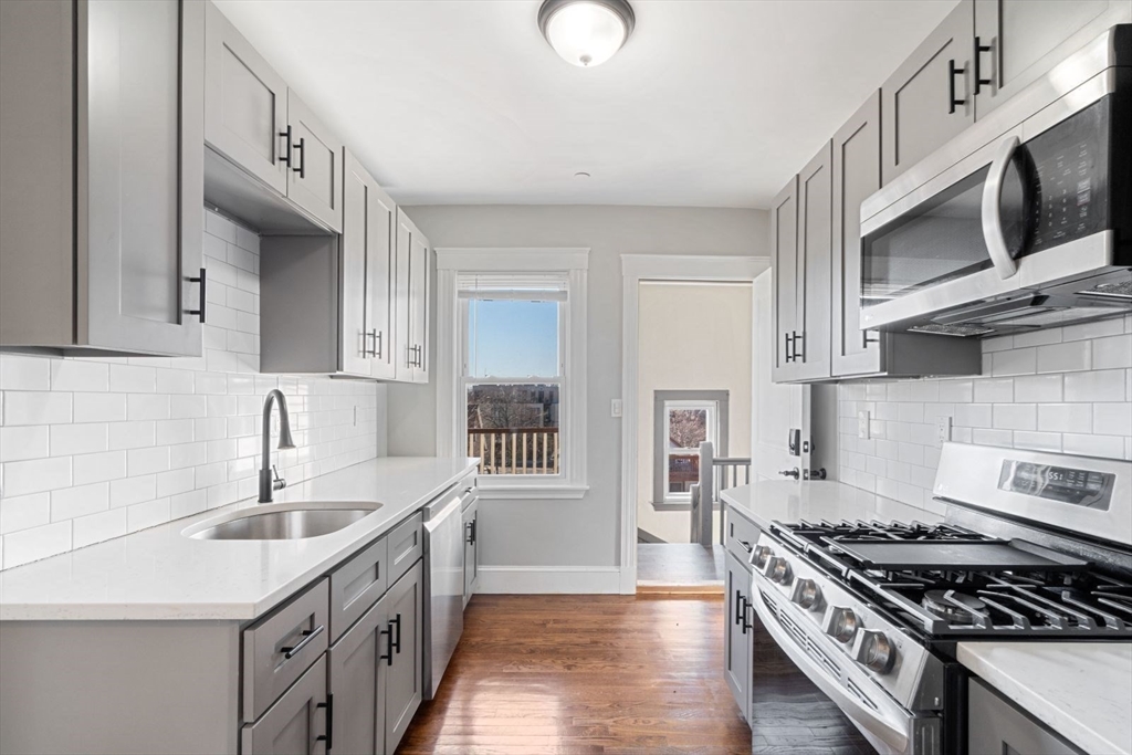 a kitchen with stainless steel appliances a sink stove and cabinets