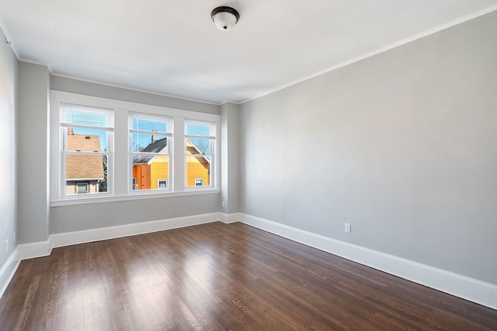 10 Centre Avenue, Unit 5 Boston, MA 02124 - Photo 11 of 24 an empty room with wooden floor and windows