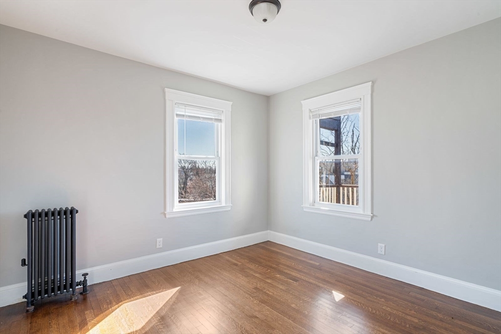10 Centre Avenue, Unit 5 Boston, MA 02124 - Photo 13 of 24 a view of an empty room with wooden floor and a window