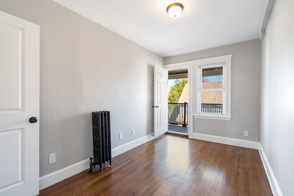 10 Centre Avenue, Unit 5 Boston, MA 02124 - Photo 6 of 24 an empty room with wooden floor and windows