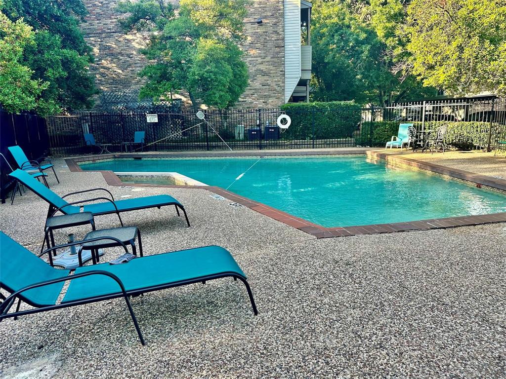 7340 Skillman Street, Unit 405 Dallas, TX 75231 - Photo 16 of 18 Outdoor swimming pool with integrated spa, surrounded by a pebble-finish deck and a brick coping