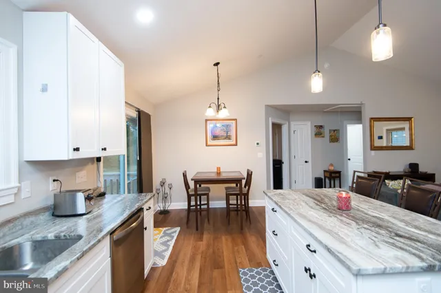 a very nice looking kitchen with granite countertop a large counter top space a sink a window and stainless steel appliances