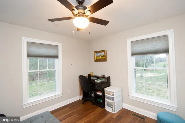 a view of a workspace with furniture and a window
