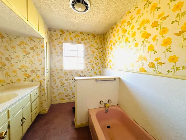 a bathroom with a tub sink and mirror
