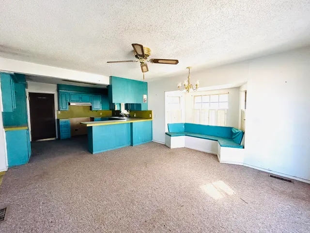 a kitchen with kitchen island stainless steel appliances a chimney a sink and a refrigerator