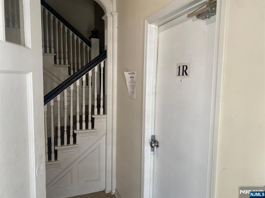29 High Street, Unit 1R West Orange, NJ 07052 - Photo 4 of 19 a view of a hallway with wooden floor and staircase