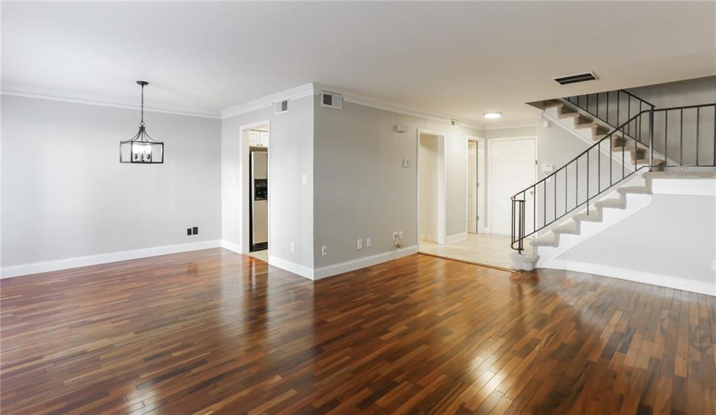 a view of empty room with wooden floor and window