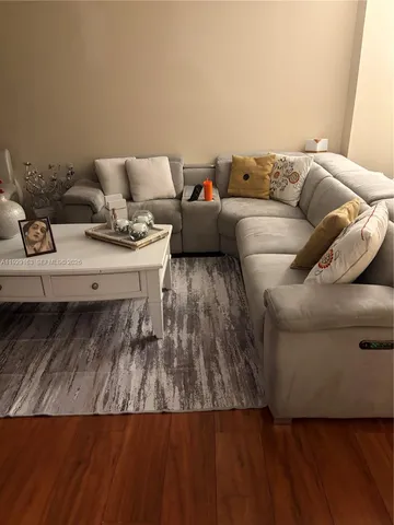 a view of a hallway with wooden floor and furniture