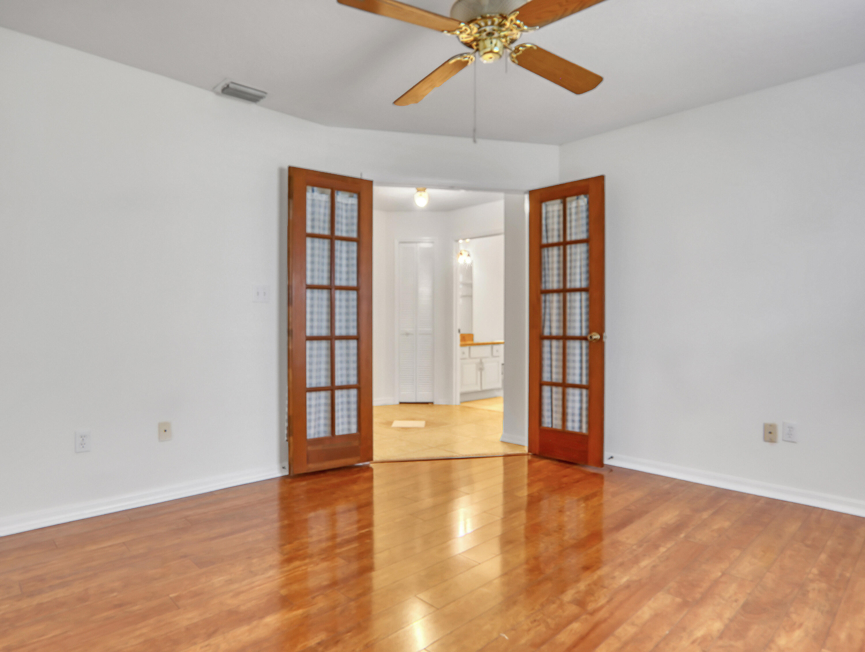 920 Turtle Pond Way Melbourne, FL 32940 - Photo 40 of 53 an empty room with wooden floor chandelier fan and windows