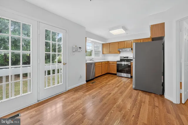 a kitchen with stainless steel appliances granite countertop a refrigerator and a stove top oven