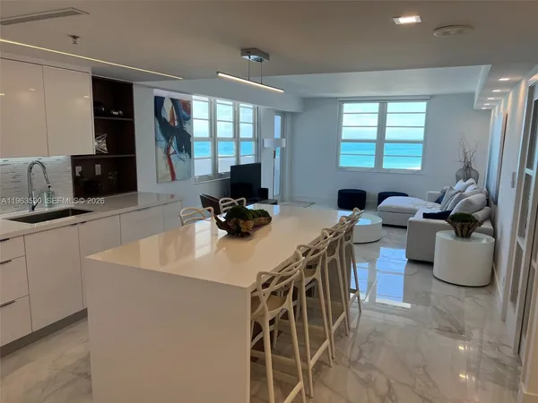 a kitchen with a sink a counter top space and living room
