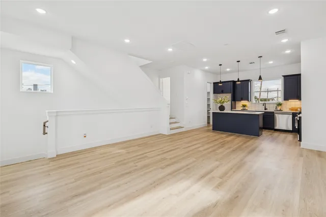 a view of a kitchen with kitchen island and stainless steel appliances
