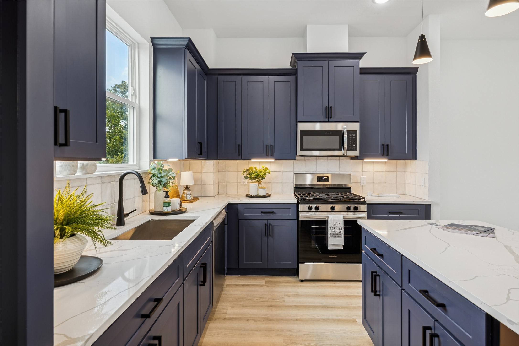 113 Milby Street Houston, TX 77003 - Photo 15 of 38 a kitchen with granite countertop wooden cabinets and a stove top oven