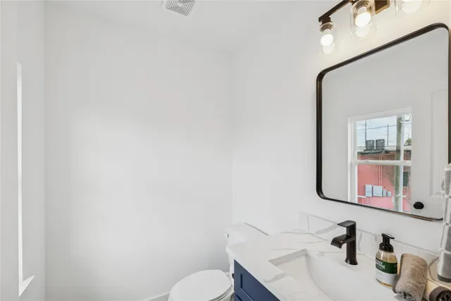a bathroom with a sink mirror and toilet