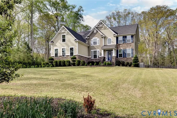 a front view of a house with a yard and trees