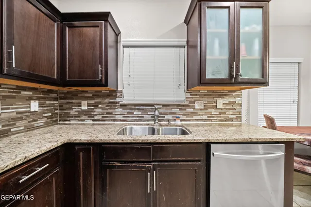 a kitchen with granite countertop a sink and a cabinets