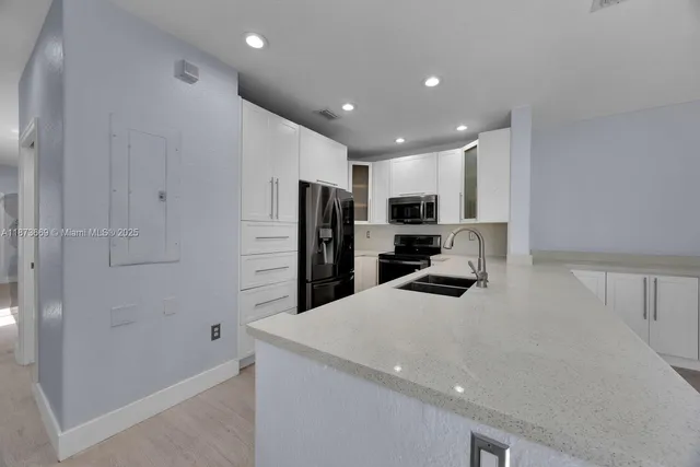 a kitchen with stainless steel appliances a refrigerator and a stove top oven