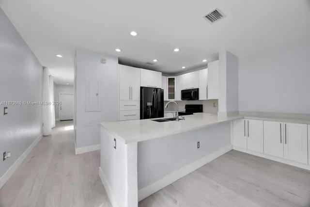 a large white kitchen with stainless steel appliances