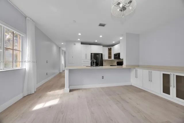 a view of kitchen with stainless steel appliances refrigerator oven and cabinets