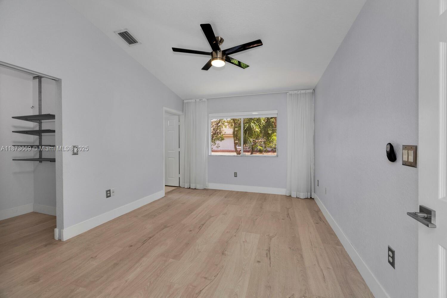 2641 Southwest 83rd Terrace, Unit 104 Miramar, FL 33025 - Photo 22 of 30 an empty room to ceiling fan and wooden floor